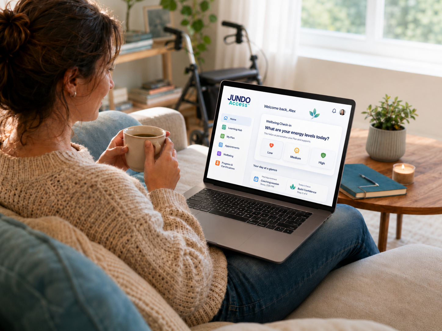 A learner relaxing at home with a warm drink while using the JUNDO Access learning platform on a laptop.